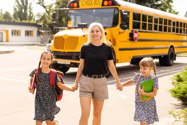 Terug naar het schoolconcept. moeder neemt afscheid van haar dochters. Ga naar school. Terug naar school concept. Kind van de basisschool. Onderwijsconcept. — Stockfoto