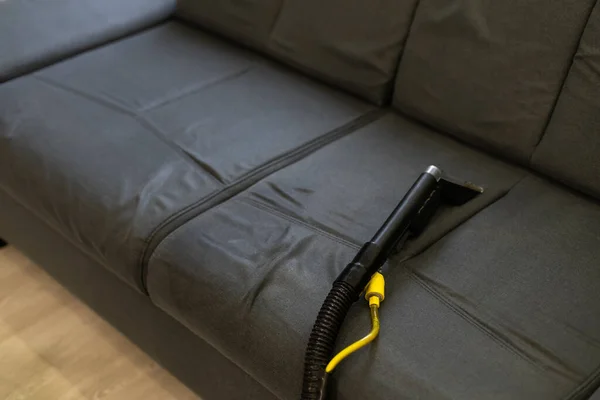 Limpeza sofá com aspirador de pó — Fotografia de Stock