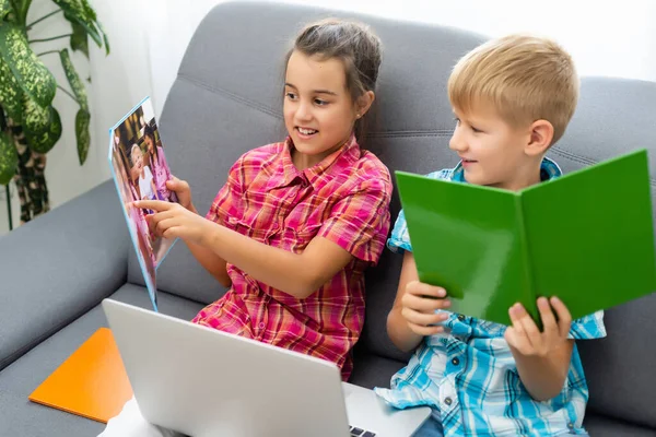 Ragazzo e ragazza, fratello e sorella studiano a casa. Una ragazza guarda una video lezione o una conferenza online. — Foto Stock