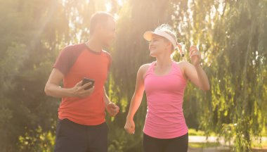 Genç çift, bir kır yolu, egzersiz ve zindelik konsepti üzerinde koşarken sağlıklı bir yaşam tarzının keyfini çıkarıyor.