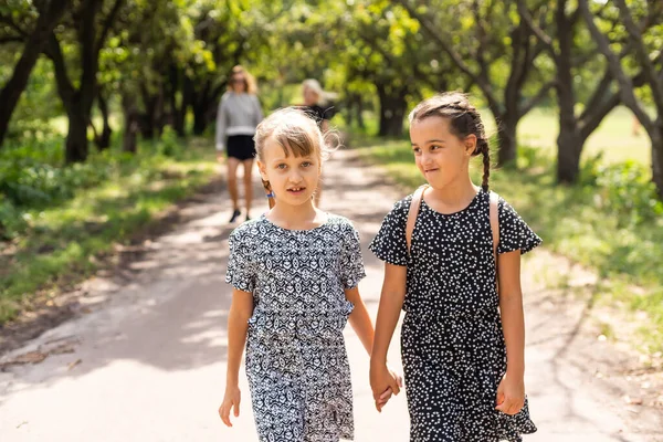 Két boldog iskolás lány a parkban — Stock Fotó