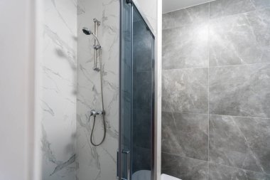 Gri fayanslı modern banyo, pürüzsüz, lüks iç döşeme.