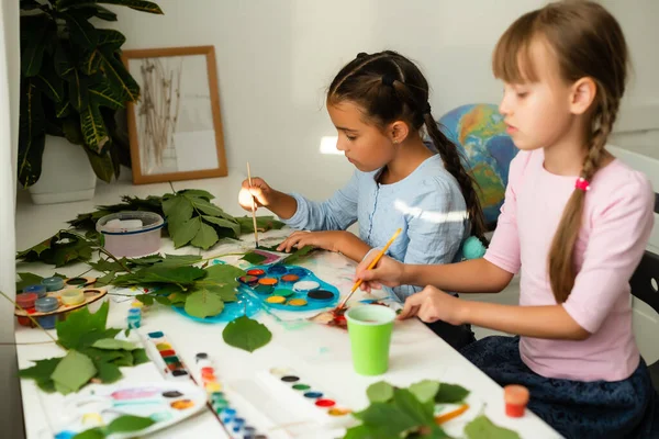 Two schoolgirls paint the leaves — Stock Photo, Image