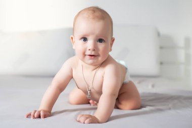 Bebek çocuk beyaz güneşli yatak odasında. Yeni doğan çocuk yatakta rahatlatıcı. Genç çocuklar için kreş