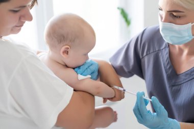Şırıngalı, gergin anne ve bebeği olan çocuk doktoru.