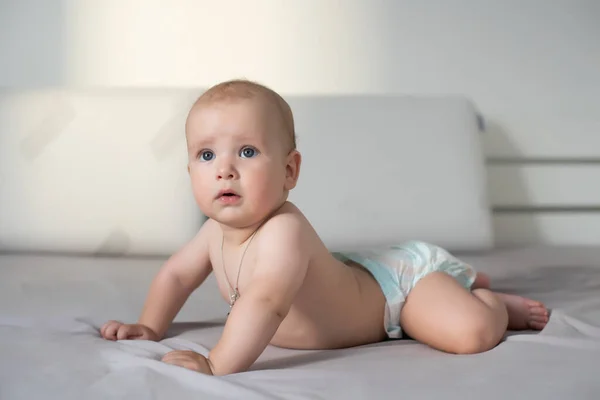 Lindo bebé sonriente en un sofá gris —  Fotos de Stock