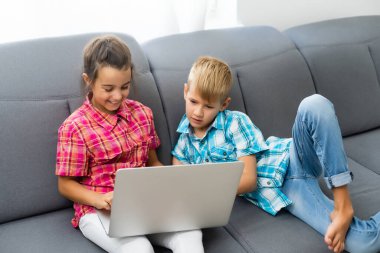 Tatlı çocuklar eğitim için dizüstü bilgisayar, online çalışma, evde öğrenim, uzaktan öğrenim gören kız ve erkek çocukları. Evde eğitim için yaşam tarzı kavramı.