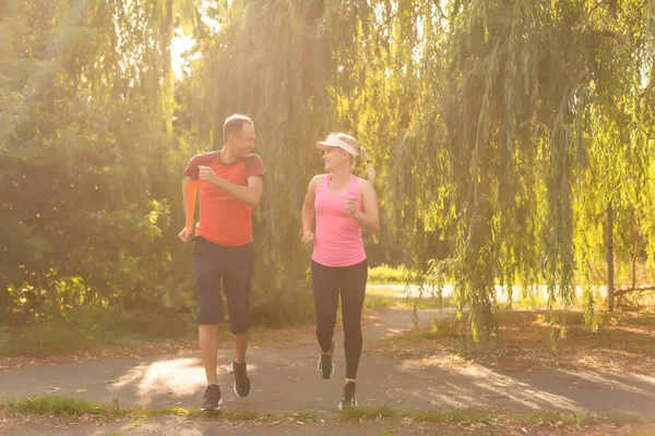 Şehir sporları - güzel bir yaz gününde şehirde spor yapmak için koşan çift