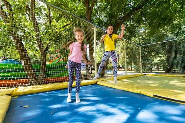 Jovens caucasianos crianças saltar em um trampolim. — Fotografia de Stock