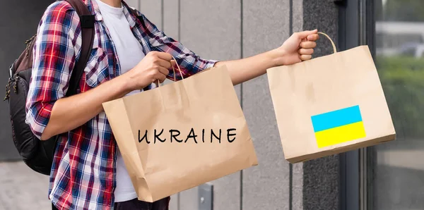 Ένας άνδρας κρατά ένα κουτί βοήθειας για τους Ουκρανούς πρόσφυγες και τους φτωχούς πολίτες που βρίσκονται σε έναν πόλεμο μεταξύ Ουκρανίας και Ρωσίας. Σχέδιο ανθρωπιστικής βοήθειας. Δωρεά για πρόσφυγες. — Φωτογραφία Αρχείου
