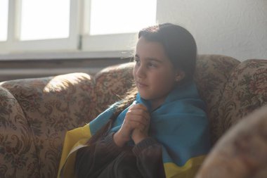 Ukrayna için dua et. Ukrayna bayrağı taşıyan bir çocuk. Ulusal bayrak sallayan küçük kız barış için dua ediyor..