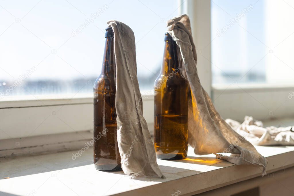 Glass bottle filled with gasoline, a so called Molotov Cocktail, on the window in the house