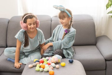 Paskalya 'da yumurta avına çıkan iki kız kardeş. Sevimli çocuklar Paskalyayı evde kutluyor..