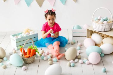 holding arka planda büyük sarı yumurta ve bunny Paskalya sarışın kız