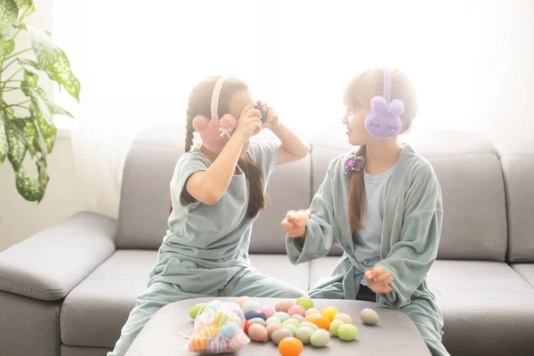 Paskalya 'da yumurta avına çıkan iki kız kardeş. Sevimli çocuklar Paskalyayı evde kutluyor.. — Stok fotoğraf