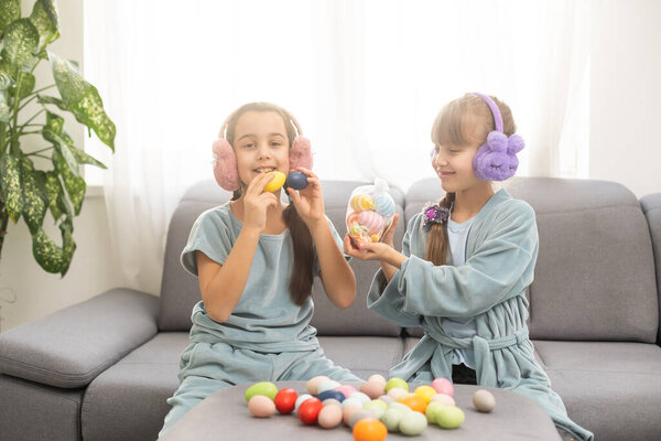 Две маленькие девочки играют с пасхальными яйцами. Пасхальная охота