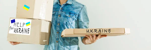 Ein Mann hält eine Schachtel mit humanitärer Hilfe für die Ukraine — Stockfoto