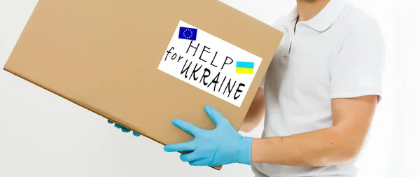 Un hombre tiene una caja de ayuda para los refugiados ucranianos y los ciudadanos pobres que se encuentran en una guerra entre Ucrania y Rusia. Concepto de ayuda humanitaria. Donar para los refugiados. —  Fotos de Stock