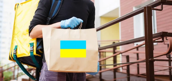 Mężczyzna posiada pudełko pomocy dla ukraińskich uchodźców i biednych obywateli, którzy znajdują się w stanie wojny między Ukrainą a Rosją. Koncepcja pomocy humanitarnej. Darowizna dla uchodźców. — Zdjęcie stockowe