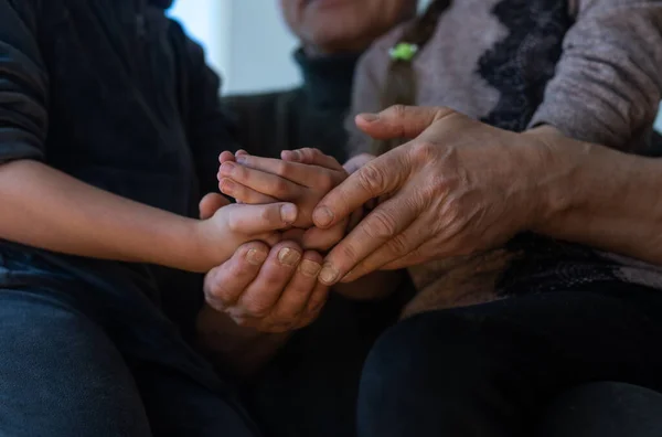 Grandfather and two granddaughters hugging on sofa at home — Stock Photo, Image