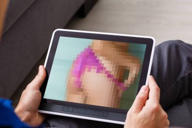 Tablet ekranda seksi kadınların videosunu izleyen adam, bulanık konsept.