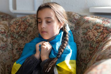 Ukrayna için dua et. Ukrayna bayrağı taşıyan bir çocuk. Ulusal bayrak sallayan küçük kız barış için dua ediyor..