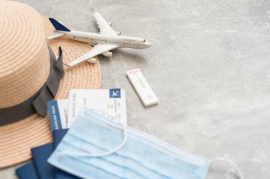Şırınga, oyuncak uçak, tıbbi maske ve içinde Covid-19 aşısı olan aşı sertifikası olan pasaport. Covid-19 salgını sırasında seyahat kavramı.