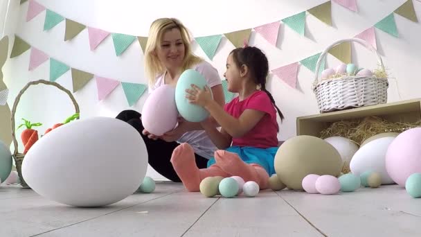 Hübsches kleines Mädchen verschenkt verzierte Eier und Grußkarten an Mutter und Großmutter beim Familienessen zu Ostern — Stockvideo