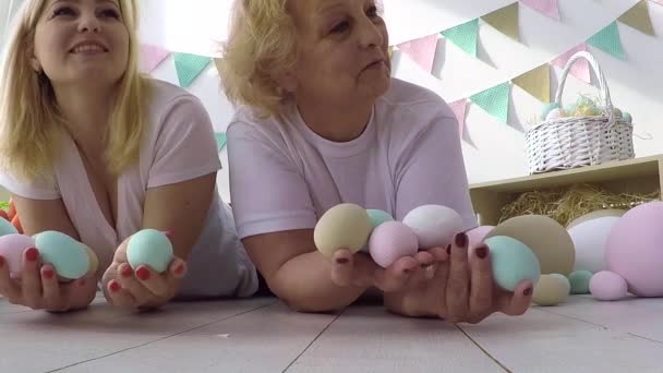 Mooi klein meisje geven versierde eieren en wenskaarten naar moeder en grootmoeder op Pasen familie diner — Stockvideo