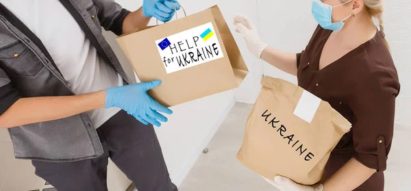 En man håller en låda med humanitärt bistånd till ukrainska — Stockfoto