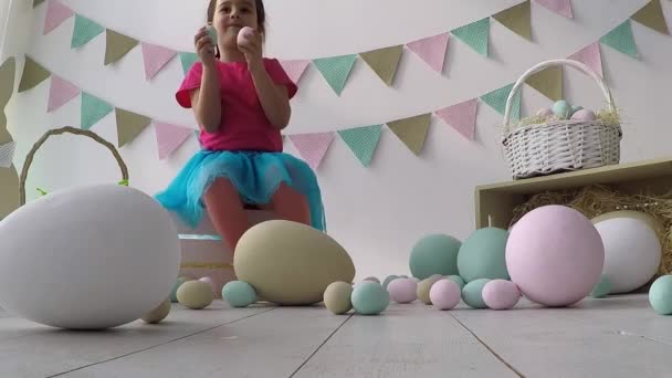 Pasen meisje spelen met paaseieren, op de vloer veel paasinrichting — Stockvideo