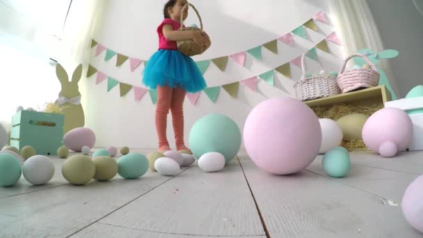 Schattig klein meisje dat kleurrijke paaseieren schildert. Ze maakte haar handen en gezicht vuil. Pasen traditie. — Stockvideo