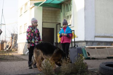 Ukrayna askeri göçü. Bavullu iki küçük kız. Ukrayna bayrağı, yardım et. Kriz, askeri çatışma