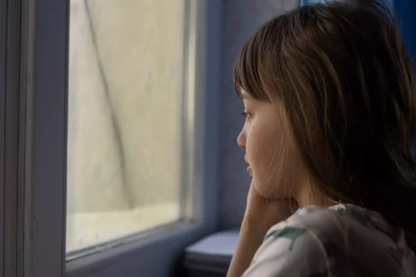Kleines trauriges Mädchen am Fenster. Missbrauch von Kindern — Stockfoto