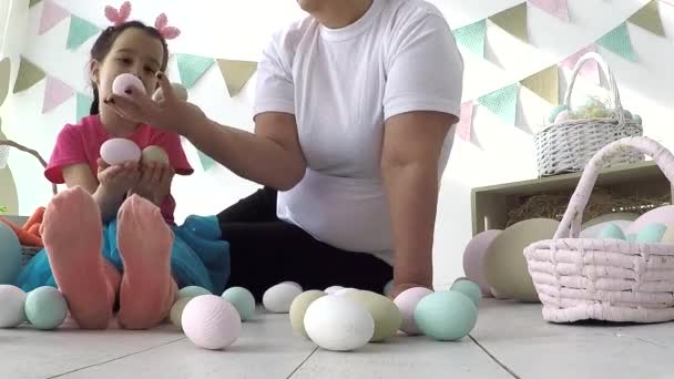 Páscoa menina brincando com ovos de Páscoa, no chão um monte de decoração de Páscoa — Vídeo de Stock
