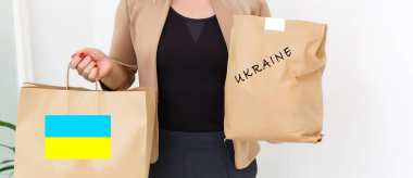 Bir adam Ukraynalı mülteciler ve kendilerini Ukrayna ve Rusya arasında savaşta bulan yoksul vatandaşlar için bir kutu yardım tutuyor. İnsani yardım kavramı. Mülteciler için bağış.