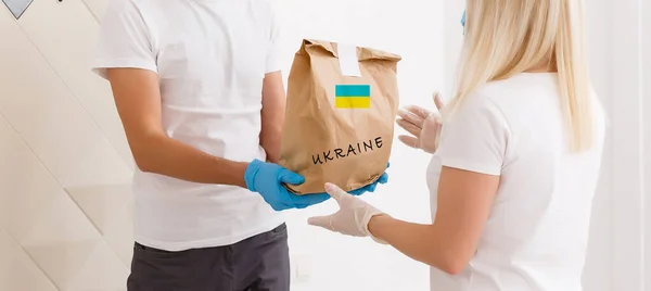 Een man houdt een doos met humanitaire hulp aan Oekraïne — Stockfoto