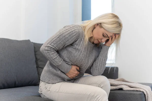 Femme couchée au lit souffrant de douleurs à l'estomac — Photo