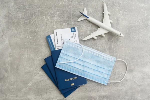 Tıbbi bir maskeyle uçan bir uçak. Kavram: Uçakta güvenliği sağlamak. Sosyal mesafeden hava yoluyla seyahat etmek. Gezilerde doktorların tavsiyelerine uymak. Sınırlar açılıyor.