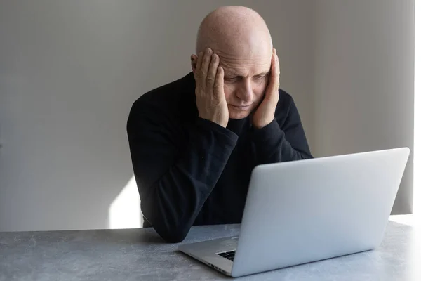 Nieszczęśliwy przygnębiony starszy mężczyzna siedzi przy biurku z laptopem, sfrustrowany zestresowany wygląd — Zdjęcie stockowe