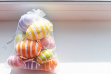 Yaratıcı bir şekilde Paskalya yumurtalarını beyaz arka planda bir çantaya boyamış. Düz yat, boşluğu kopyala.