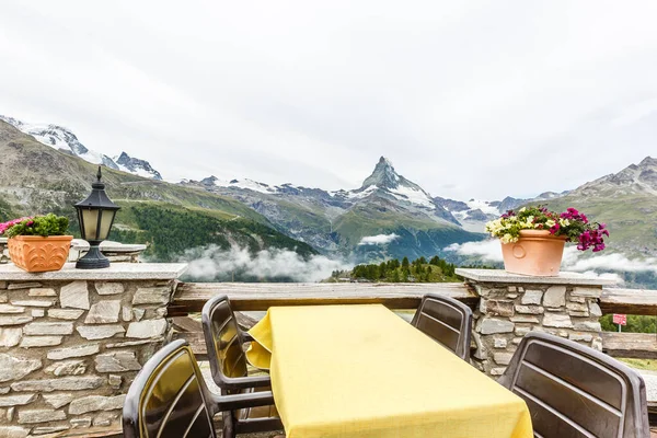 Bella vista sul ristorante circondato da lago nebbia e montagne con tavolo vuoto — Foto Stock