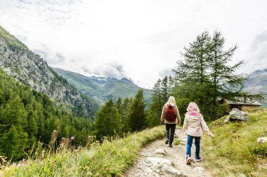 Manzaralı dağlarda mutlu bir aile yürüyüşü