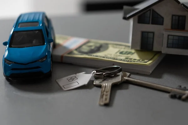 Flat lay toy car, toy house, keys with remote control alarm and money on the table — Stock Photo, Image