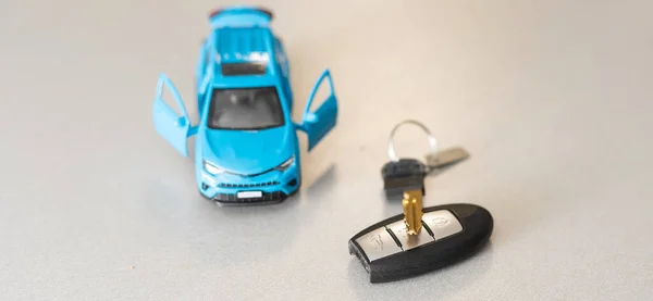 Игрушечный автомобиль и ключи изолированы на белом фоне — стоковое фото