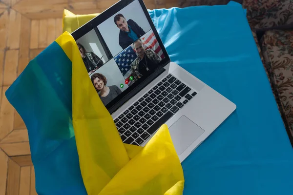 Ноутбук с видеоконференцией возле флага Украины — стоковое фото