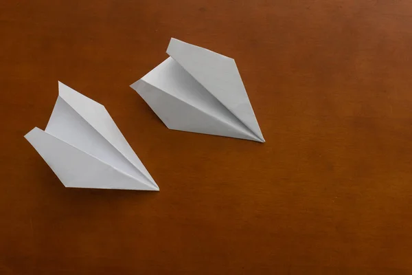 Δύο χάρτινα αεροπλάνα σε ξύλινο γραφείο — Φωτογραφία Αρχείου