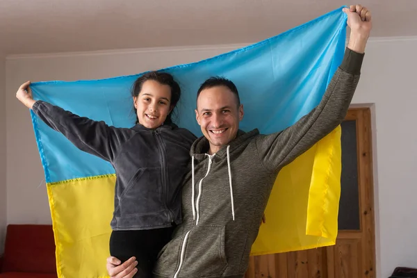 Familie mit einem Kind blickt in Kamera und ukrainische Flagge — Stockfoto