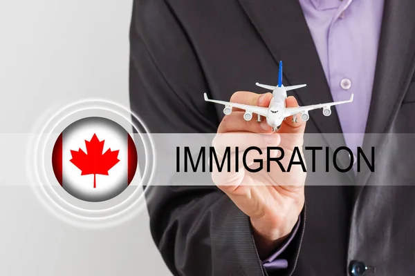 拿着加拿大国旗和"移民"这个词的人。虚拟按钮 — 图库照片