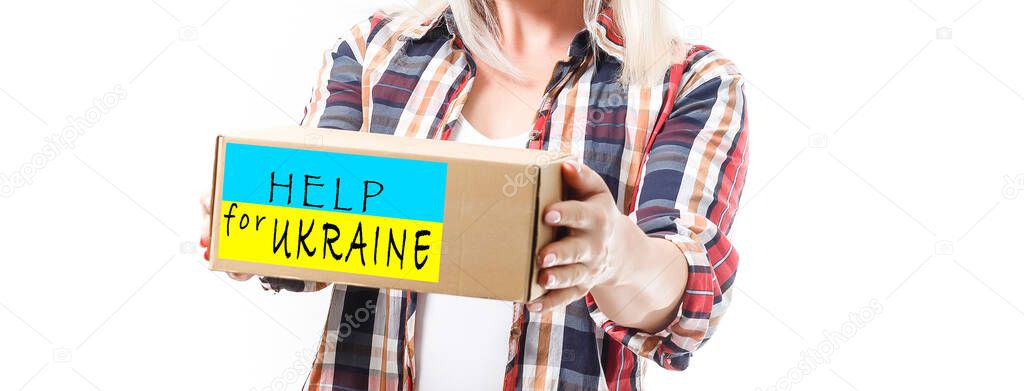 A man holds a box of aid for Ukrainian refugees and poor citizens who find themselves in a war between Ukraine and Russia. Humanitarian aid concept. Donate for refugees.